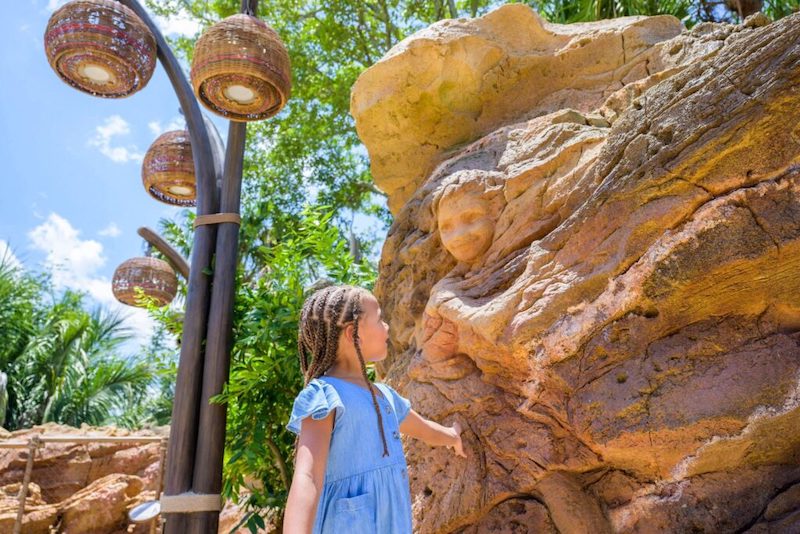 Menina e pedra esculpida na atração de Moana - Journey of Water no Epcot da Disney Orlando